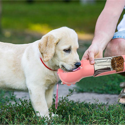 Portable pet water bottle providing hydration to a dog outdoors.
